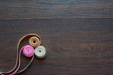 Decorative satin ribbon on dark wooden background