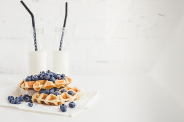 delicious breakfast of waffles with blueberries and milk with copy space
