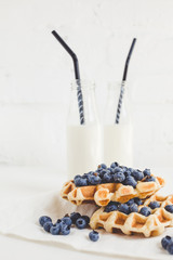 delicious breakfast of fresh waffles with blueberries and milk