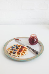 waffle with jam, blueberries and vintage knife on plate