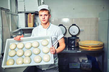 Man cooks in the kitchen preparing dough