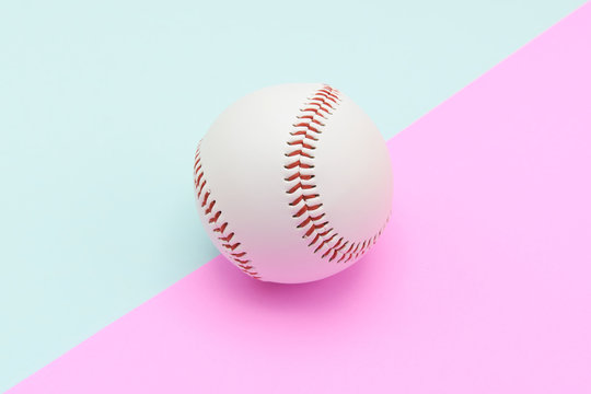 Isolated center baseball on a Pink and Turquoise color background and red stitching baseball. copy space.