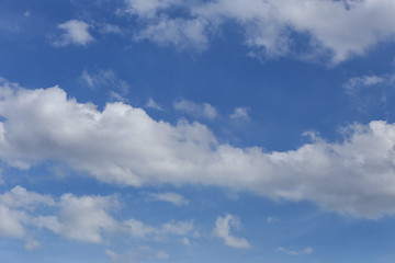 Blue sky with bright white clouds in daylight.