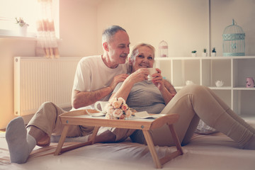 Senior couple in bed. Senior people drinking coffee in bed.