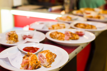 Fried meat rolls in a white plate on a bar rack