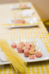 Raw pasta and sausage on a white plate
