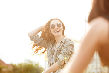 Young attractive woman in sunglasses having fun outdoors