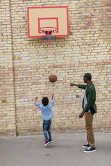 Obraz na płótnie Canvas adorable african-american father and son playing basketball together