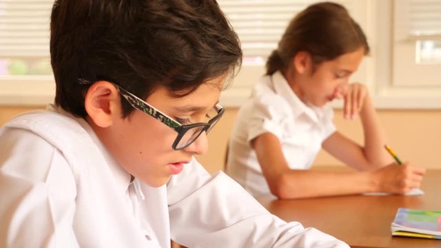 education, people and learning concept - group of students with notebooks writing test at school. 4k. Slow motion