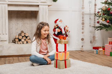 Obraz na płótnie Canvas girl with stack of christmas gifts