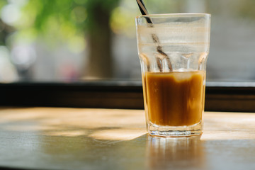 Glass of citrus coffee on the desk front window.