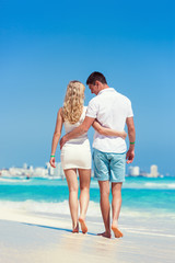 Fototapeta na wymiar Romantic couple walking on beach and enjoying life