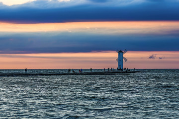 Windmill in Swinoujscie by the Baltic sea by sunset with pink and blue color.