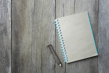 notepad book is placed on a brown wooden floor.