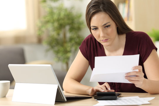 Attentive woman calculating accountancy at home