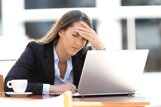 Businesswoman suffering head ache in a coffee shop