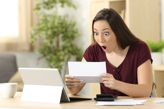 Amazed woman reading good news in a letter
