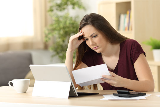 Worried woman calculating accountancy reading a letter