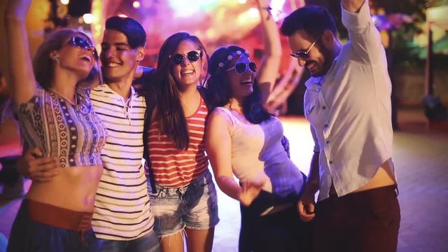 Group of friends having fun and dancing at concert
