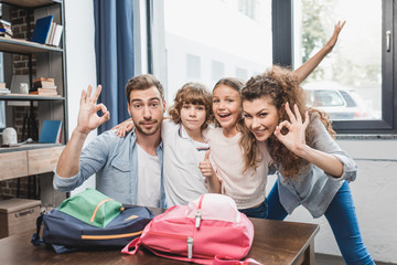 parents showing ok signs with kids ready for rist day in school