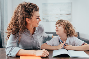 Fototapeta premium beautiful young mother and son doing homework together