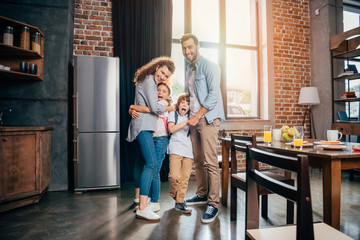 young happy family embracing on kitchen