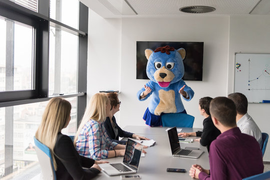 boss dresed as bear having fun with business people in trendy office