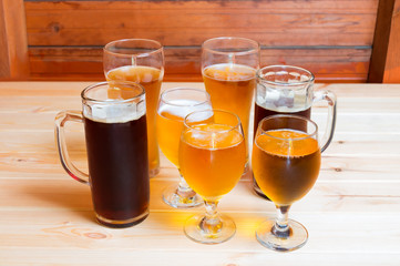 Beer glasses and beer mugs on wooden table. Selective focus