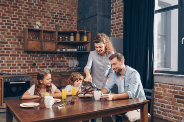 young happy family having breakfast in loft kitchen
