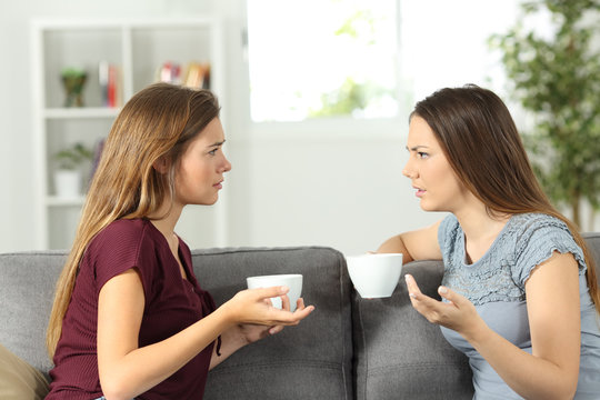 Two friends talking seriously at home