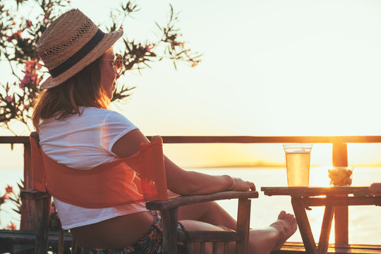 Young woman enjoying sunset at a beach bar