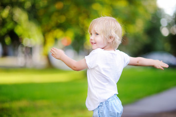 Cute little boy having fun in sunny summer park