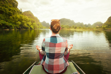 Woman traveling by boat on river amidst the scenic karst mountains