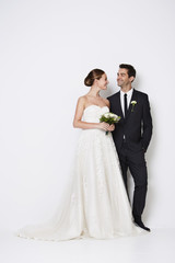 The handsome newlywed couple standing in white studio