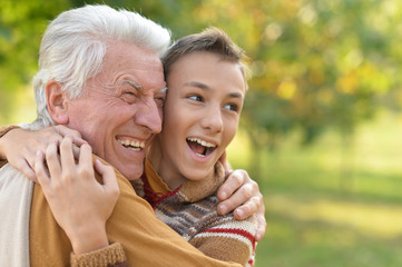 grandfather and grandson hugging  in park 