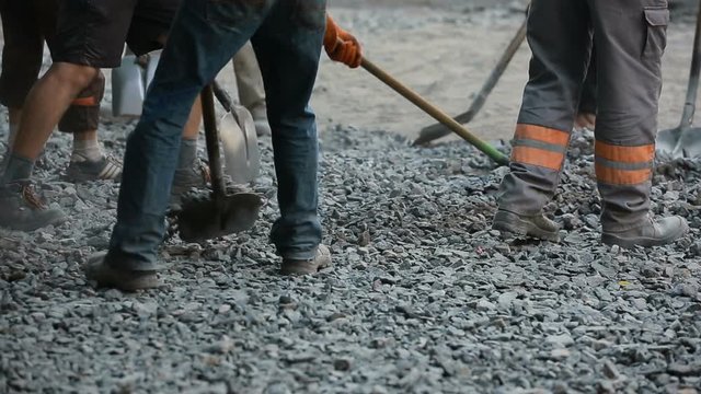 Workers Throw Gravel With Shovels