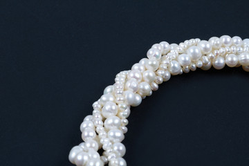 White pearl necklace on the dark background