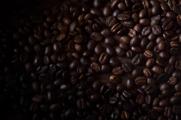 Roasted coffee beans / View of roasted coffee beans on wood background. Dark tone.
