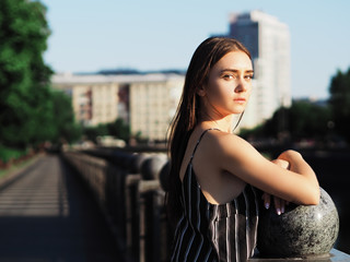 Young girl model posing at the park near the river looking back