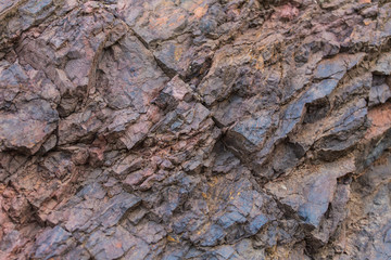 Iron ore texture closeup - natural minerals in the mine. Stone texture of open pit. Extraction of minerals for heavy industry - the texture of the rock containing iron ore and copper.
