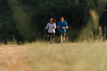 Fototapeta premium Young couple having fun racing each other on their daily jog