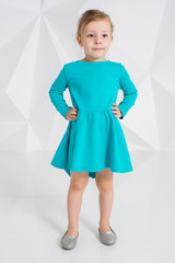 Beautiful little fashion model on white studio background. Portrait of cute girl posing in studio