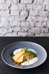 Healthy greek cuisine lunch. Quinoa salad with cheese and vegetables on black table