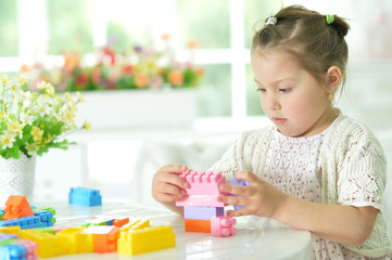 Obraz na płótnie Canvas little girl collecting plastic blocks