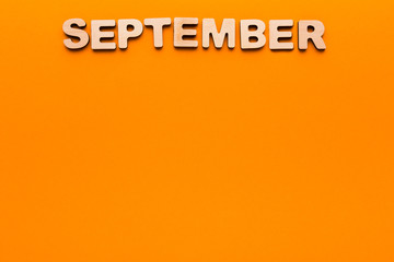 Word September on orange background