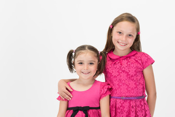 Elder and younger sisters posing together with positive smile