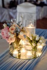 Fresh spring tulips and candles in glasses. Covered festive table. Bride idea.