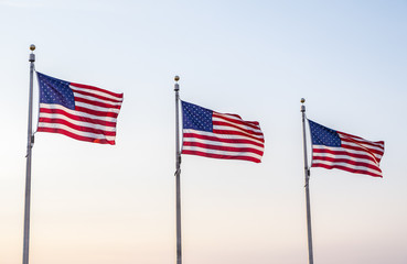 Fototapeta premium United States of America Flags Blowing in the Wind and Against the Blue Sky