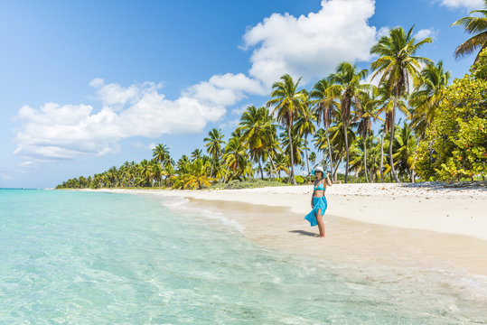 Canto de la Playa, Saona Island, East National Park (Parque Nacional del Este), Dominican Republic, Caribbean Sea. Beautiful woman on a palm-fringed beach (MR).