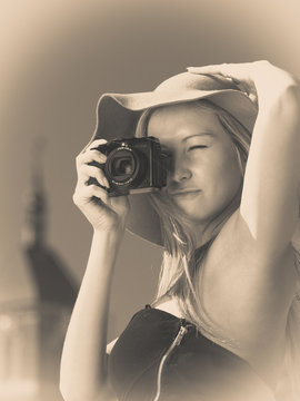 Beautiful elegant woman taking pictures with camera